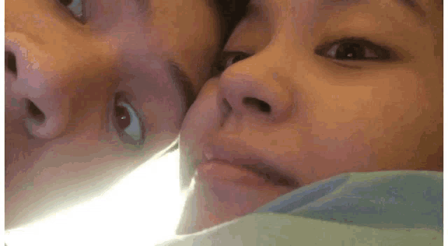 a close up of two people 's faces looking at the camera