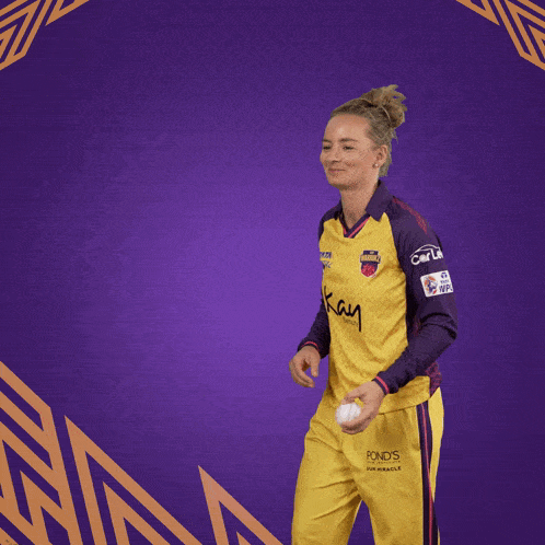 a woman wearing a yellow and purple jersey that says kay