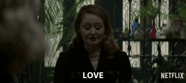 a woman in a black jacket and pearls says love in a netflix ad