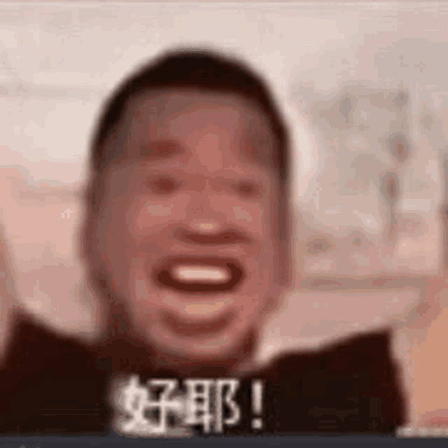 a blurry picture of a man laughing with chinese writing on his face .