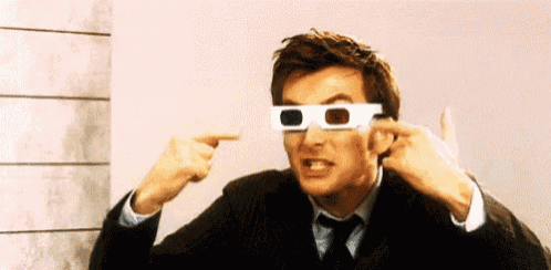 a man in a suit and tie is wearing 3d glasses and pointing at them