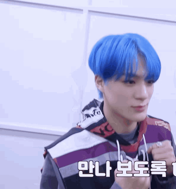 a young man with blue hair is wearing a vest that says ' nct ' on it