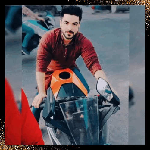 a man in a red shirt sits on an orange and black motorcycle