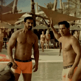 two shirtless men are standing next to each other and one of them is wearing under armour underwear