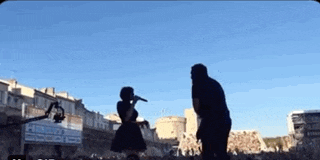 a woman singing into a microphone while a man stands next to her