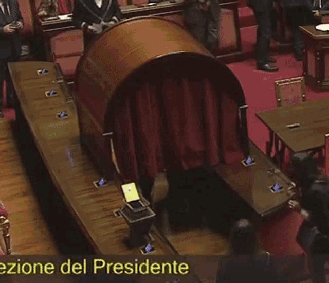 a group of people sitting in a room with the words ezione del presidente on the bottom right