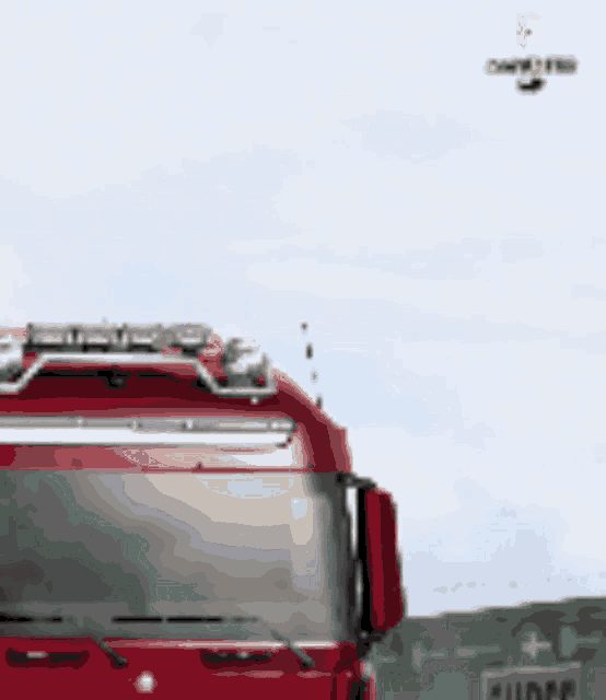 a red truck is parked in front of a green sign that says plumber