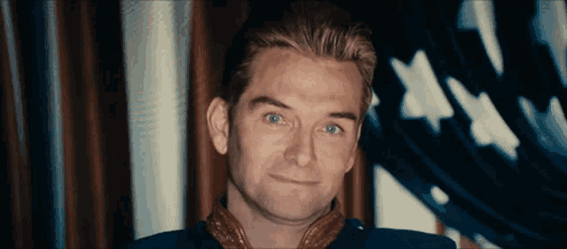 a man with blonde hair and blue eyes is smiling
