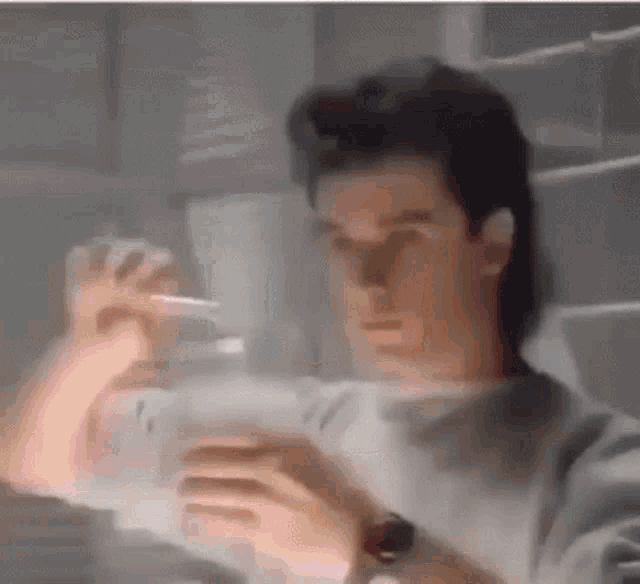 a man wearing a watch is looking at something in a dark room