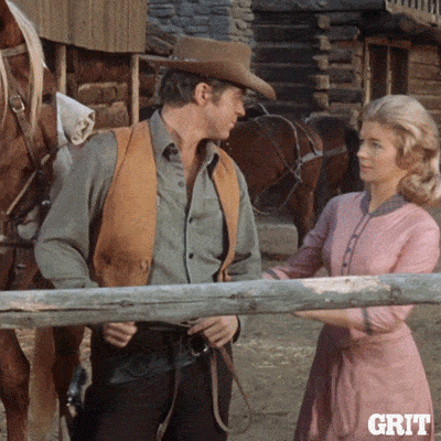a man in a cowboy hat stands next to a woman in a pink dress with the word grit on the bottom right