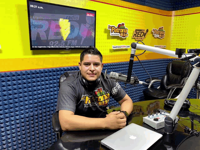 a man is sitting in front of a microphone in a radio studio