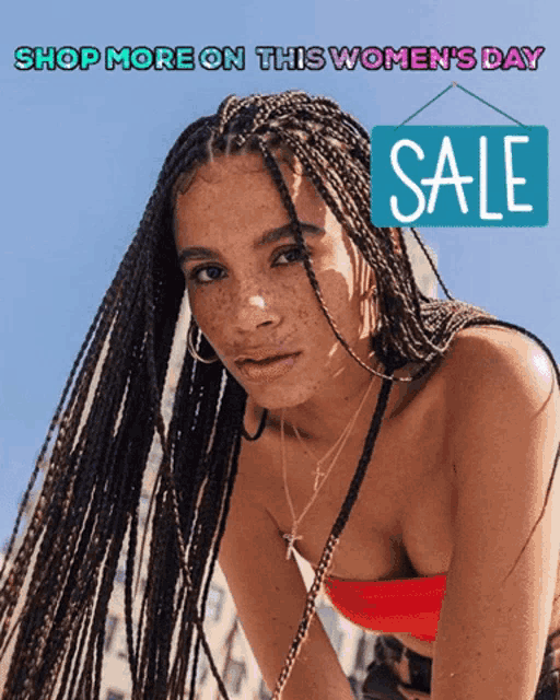 a woman with braids stands in front of a sale sign