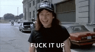 a woman wearing a hat and a black shirt is standing on a street and laughing .