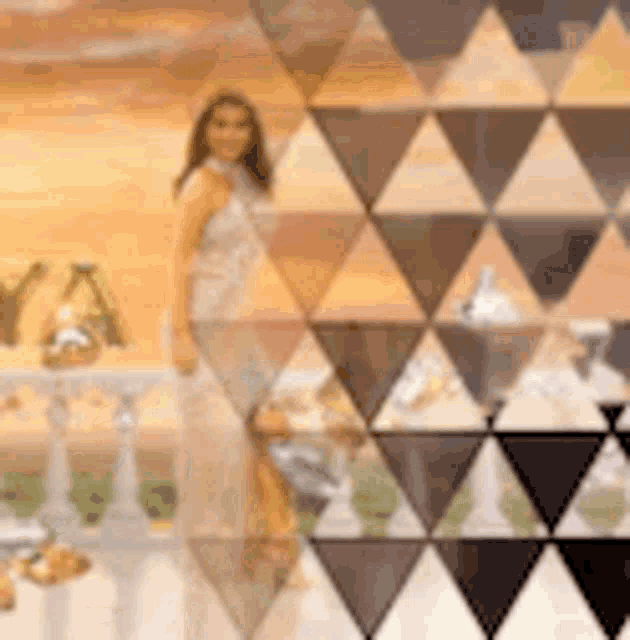 a woman in a white dress is standing on a balcony with a triangle pattern on the wall .