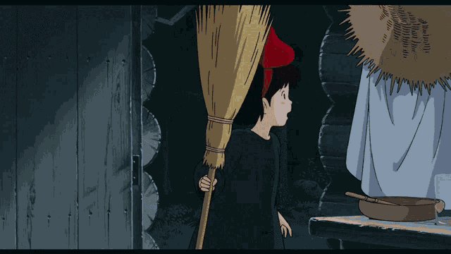 a girl in a red hat is holding a large broom