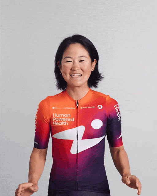 a woman wearing a shirt that says human powered health is smiling