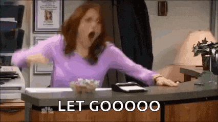 a woman in a purple shirt is yawning while sitting at a counter in an office .