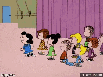 a group of peanuts characters are standing in front of a purple curtain