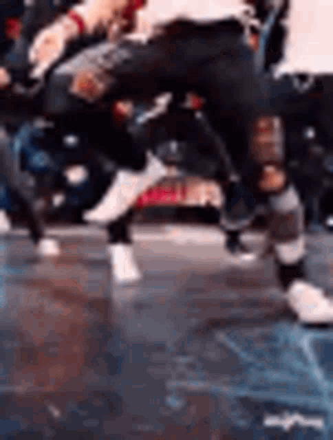 a group of people are dancing on a stage in a dark room .