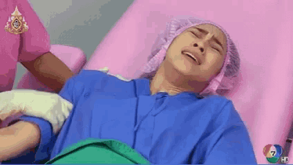 a woman in a surgical gown is laying in a hospital bed .