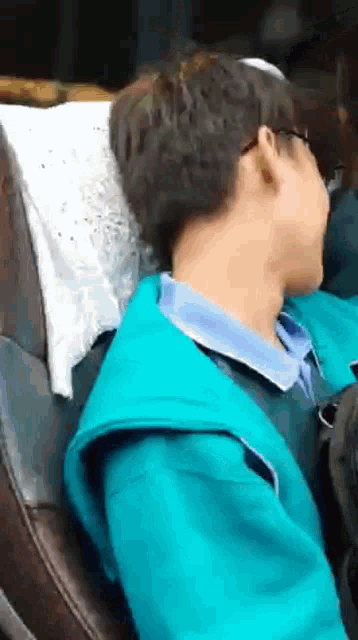 a man wearing glasses is sleeping in a car seat