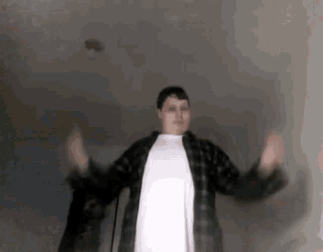 a man in a plaid shirt and a white shirt is dancing