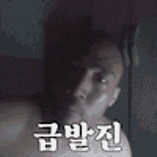a man without a shirt is taking a selfie in a dark room with chinese writing on the bottom .