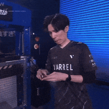 a man wearing a shirt that says yarrel on it holds something in his hands