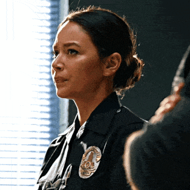 a woman in a police uniform has a badge that says los angeles