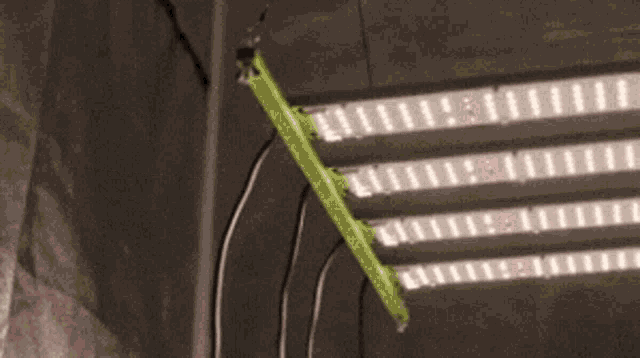 a bunch of lights are hanging from the ceiling and one of them is green