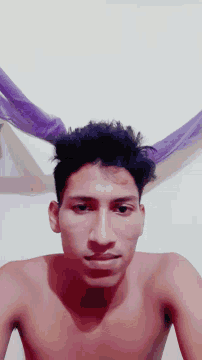a shirtless man with a bandage on his forehead