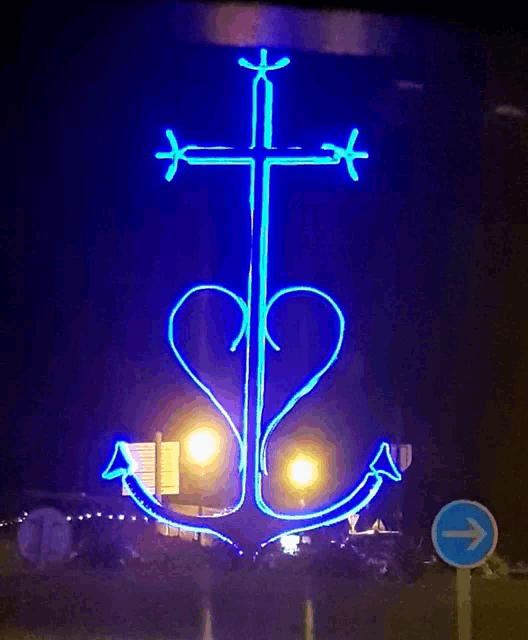 a blue neon sign with a cross and anchor