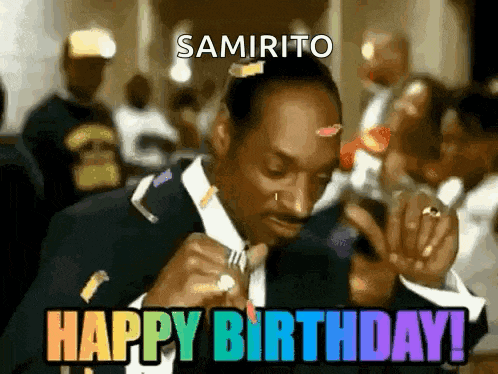 snoop dogg is wearing a suit and tie and eating a piece of food .