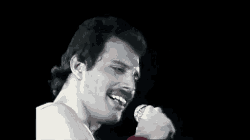 a man is singing into a microphone and smiling .