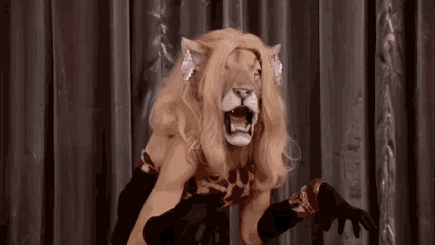 a man in a lion costume is standing on a stage with his mouth open .