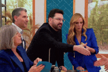 a group of people are standing around a table and one of them has glasses on