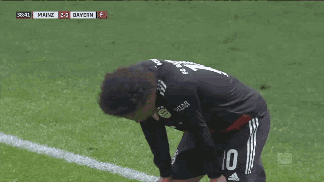 a soccer player with the number 10 on his jersey is kneeling down