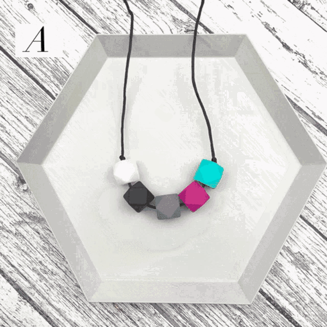 a row of bracelets with different colored beads on a wooden surface