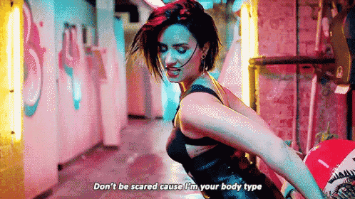 a woman in a black bra is dancing in a hallway with a red balloon .