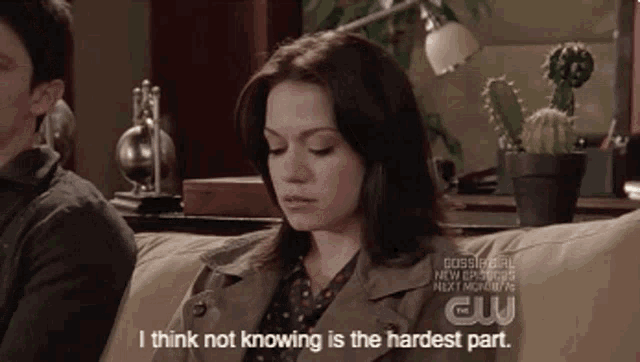 a woman is sitting on a couch with a man and says i think not knowing is the hardest part .