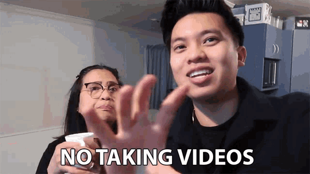 a man says no taking videos while standing next to a woman