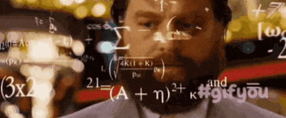 a man with a beard is standing in front of a chalkboard with equations on it .
