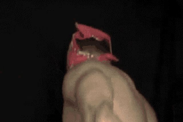 a man with a red bandana on his head is laying down on a black background .