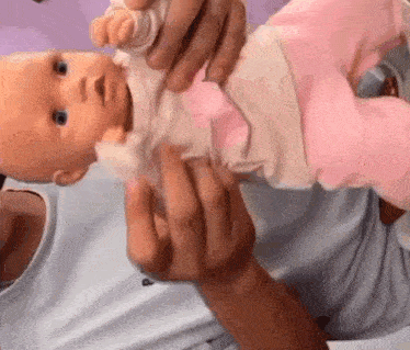 a man is holding a baby doll in his arms