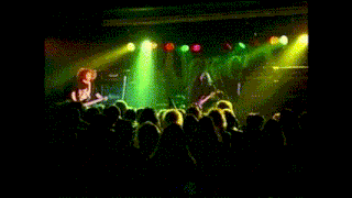 a blurred image of a person playing drums in a green light