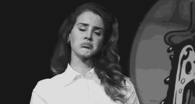 a black and white photo of a woman making a funny face with her mouth open .