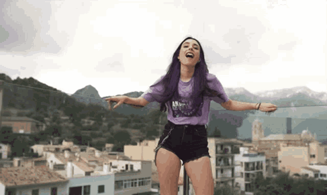 a woman with purple hair is wearing a purple t-shirt that says andrea on it