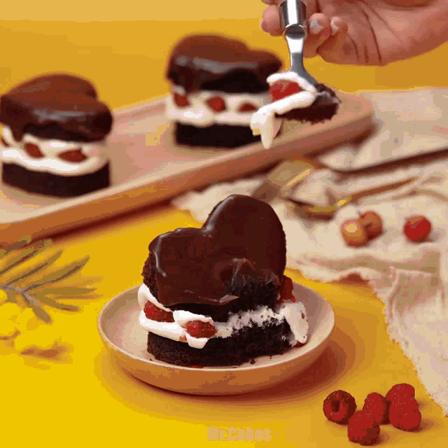 a person is holding a fork over a heart shaped cake on a plate that says mr.cakes