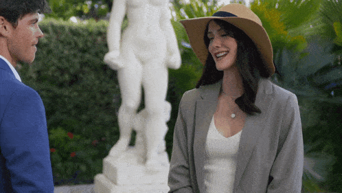 a woman wearing a hat is standing next to a man