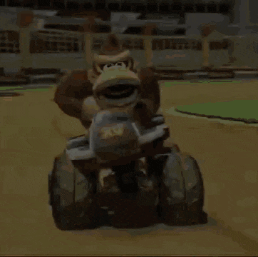 donkey kong is riding a four wheeled vehicle on a track in a video game .
